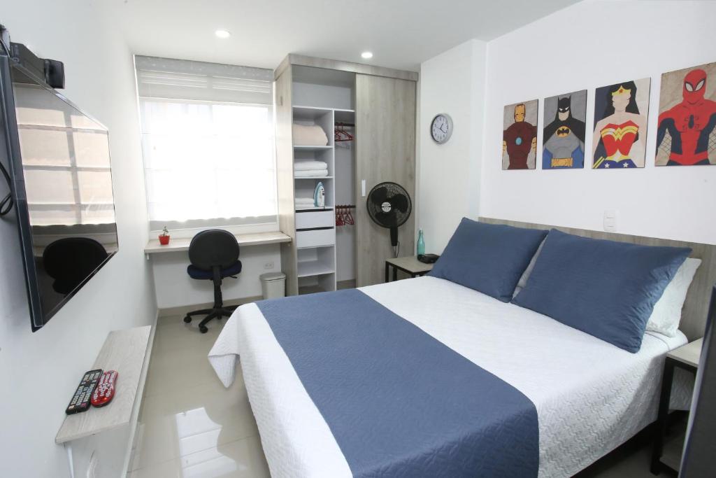 Un dormitorio con una cama azul y blanca y un escritorio en New Studio Apartment for Two en Medellín