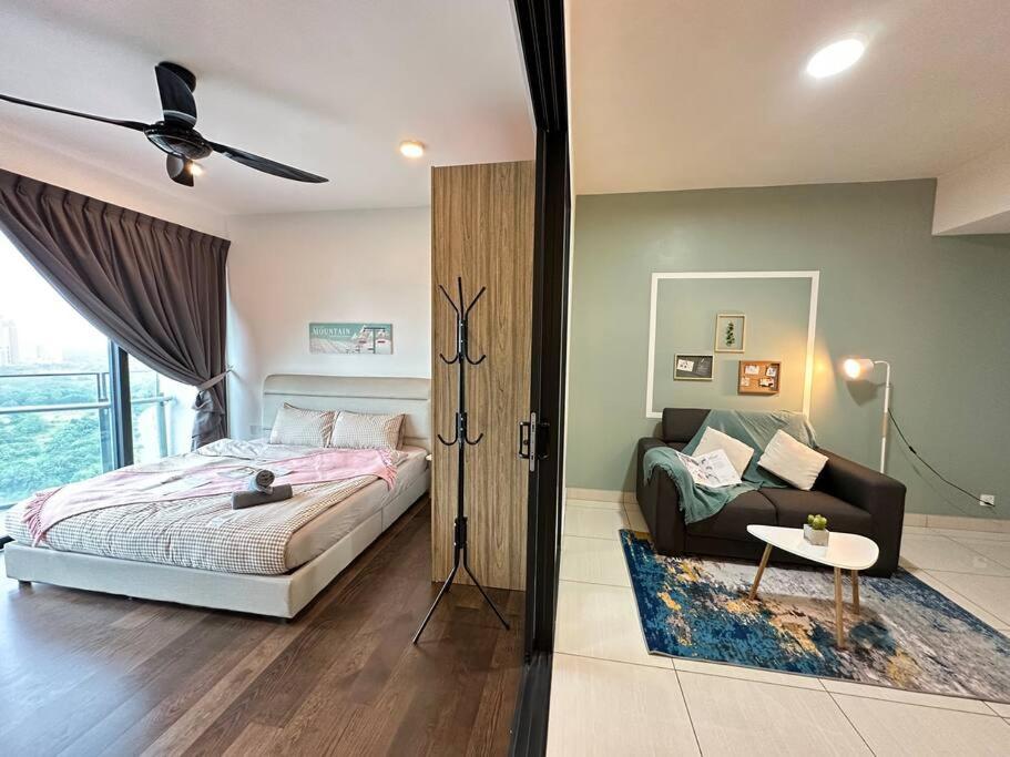 ein Schlafzimmer mit einem Bett und einer Couch in der Unterkunft Almas suites Cozy NETFLIX100mbps By STAY in Nusajaya