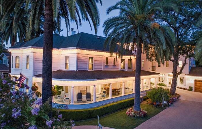 a large white house with palm trees in front of it at The River Belle Inn in Healdsburg