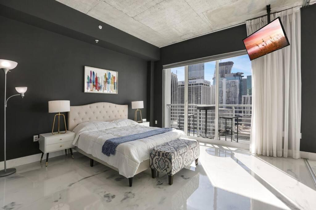 1 dormitorio con cama y ventana grande en Elegant and stylish 2/2 in the heart of downtown en Miami