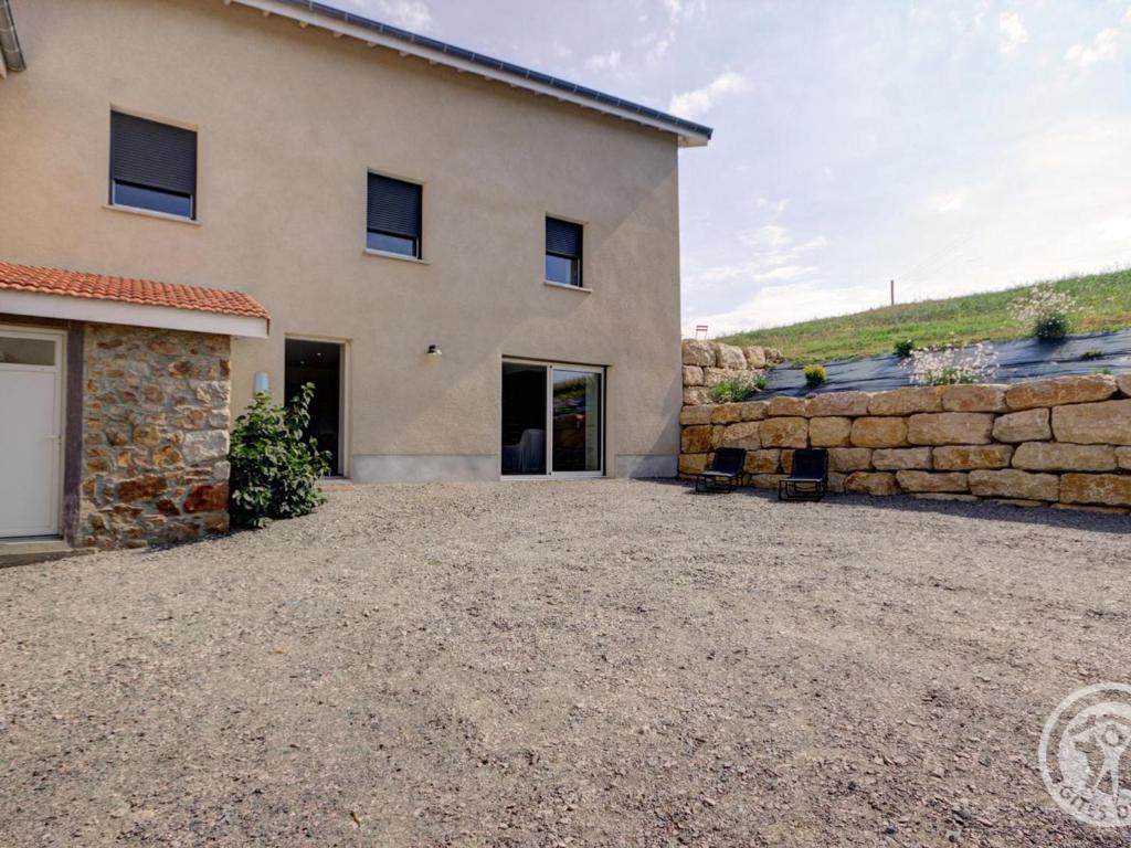 a house with a stone wall and a driveway at Gîte Panissières, 3 pièces, 8 personnes - FR-1-496-215 in Panissières