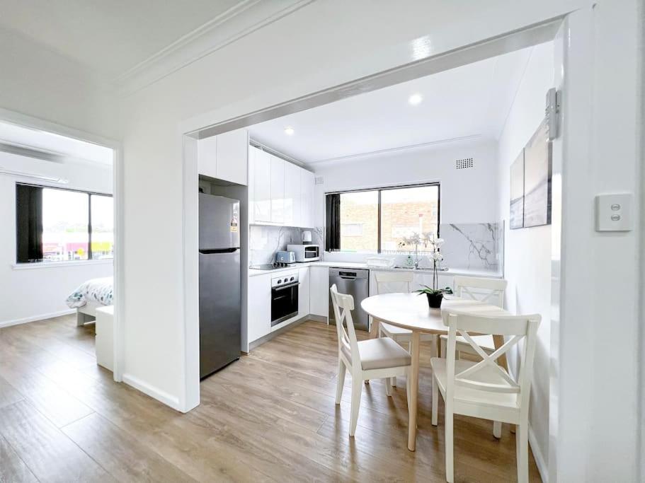 a kitchen and dining room with a table and chairs at Brand new 2 Bedrooms Apartment in Ingleburn in Ingleburn
