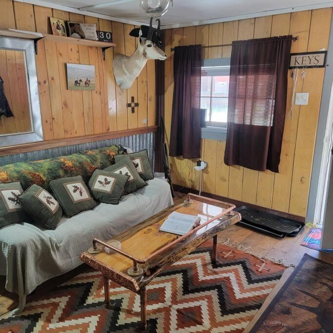 a living room with a couch and a table at Outlaw Cache in Chama