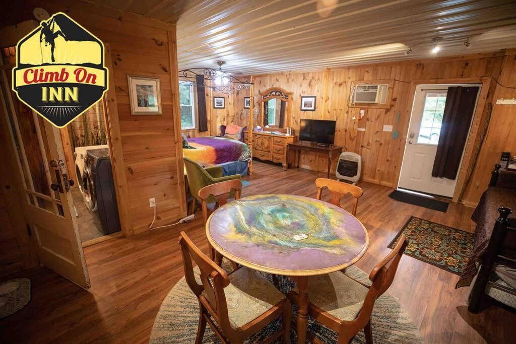 Zimmer mit einem Tisch und einem Bett in einer Hütte in der Unterkunft Climb On Inn Naturally Gorgeous Apt #2 Red River Gorge Kentucky 