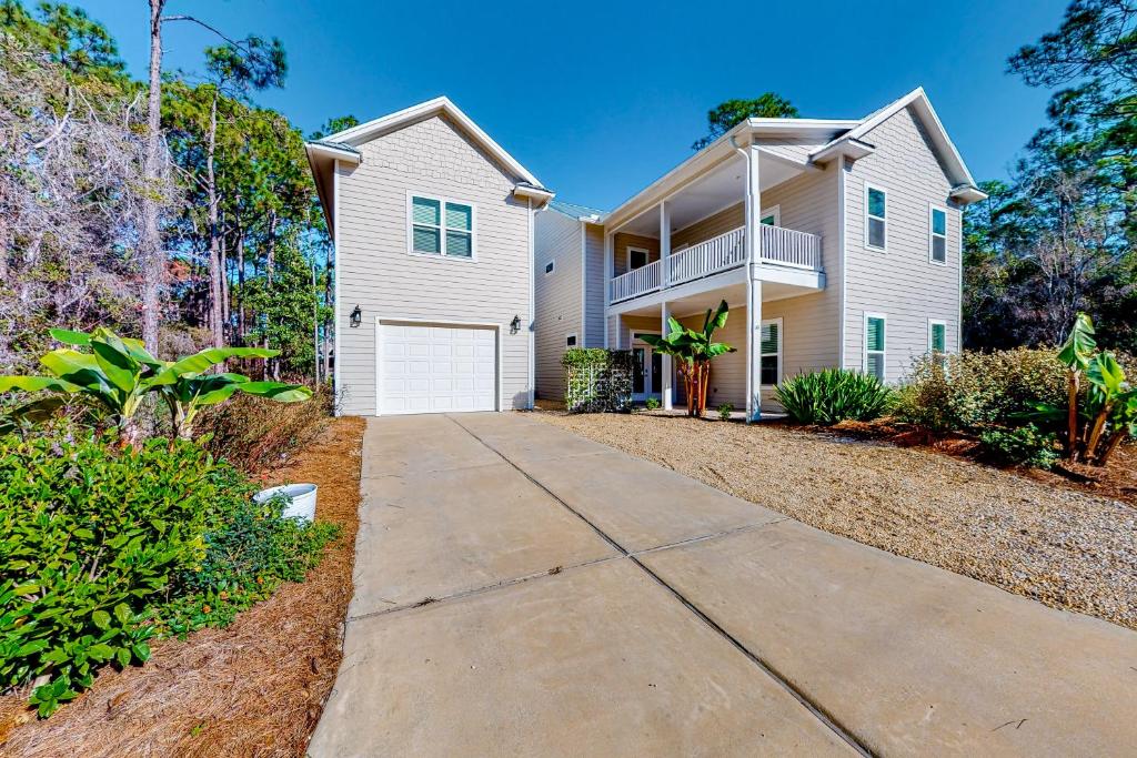 a large white house with a driveway at Calm Waters - Carriage House in Santa Rosa Beach