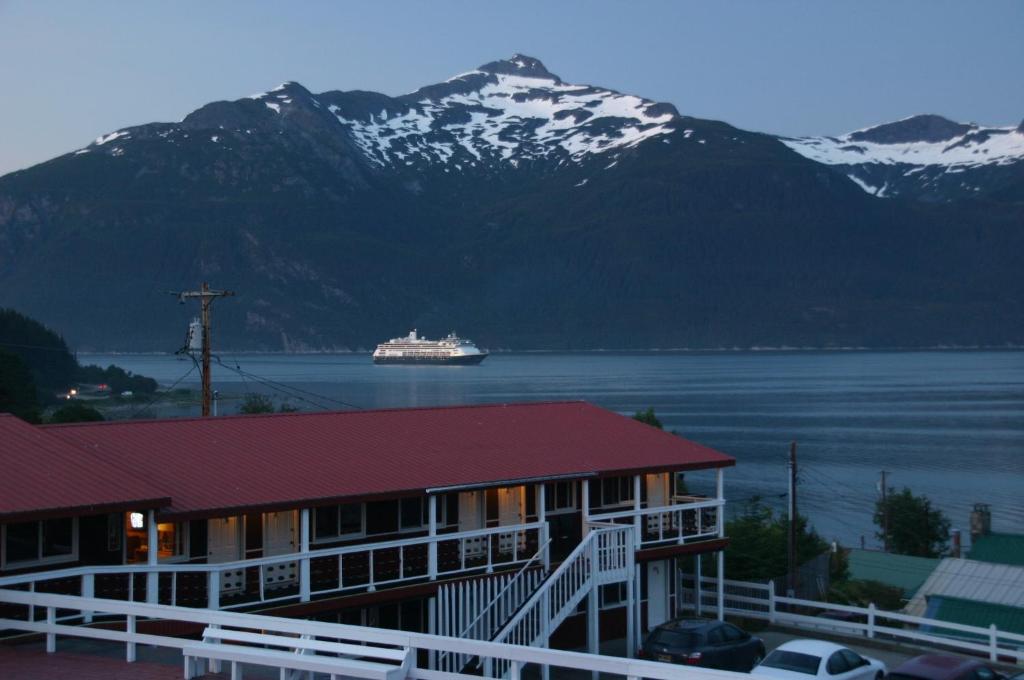 a cruise ship in a body of water with mountains at Captain's Choice Motel in Haines