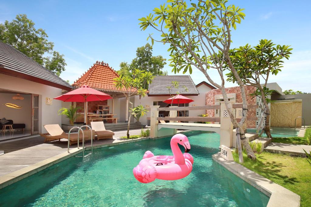a pink inflatable flamingo in the swimming pool of a house at Vivara Bali Private Pool Villas & Spa Retreat in Jimbaran