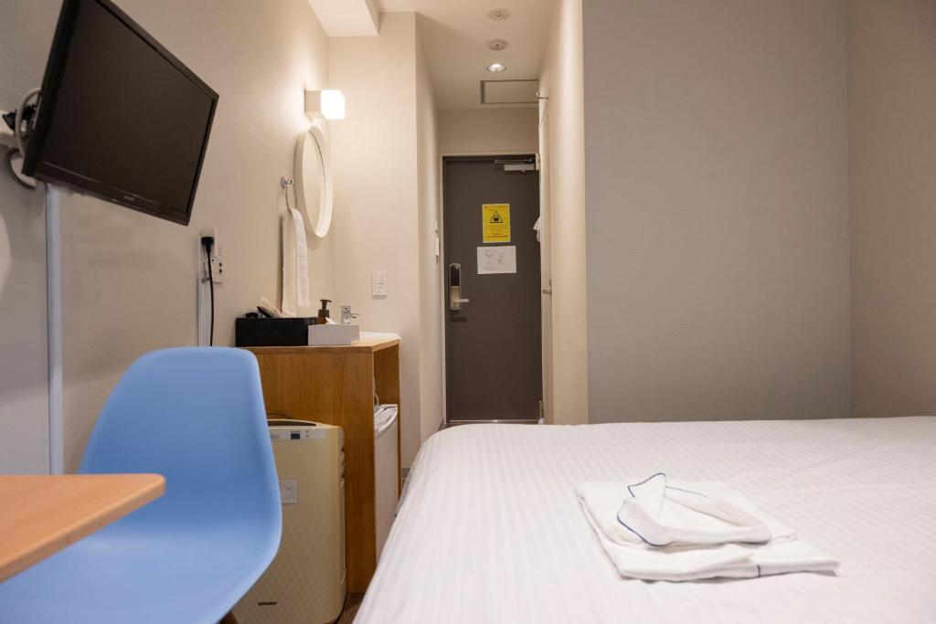 a hospital room with a bed and a tv at ELE Hotel Ginza East in Tokyo