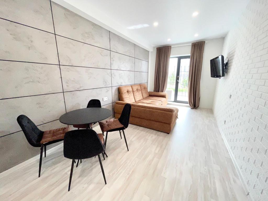 a living room with a table and chairs and a couch at Апартаменты в Аркадии - Arcadia Sky Apartments in Odesa