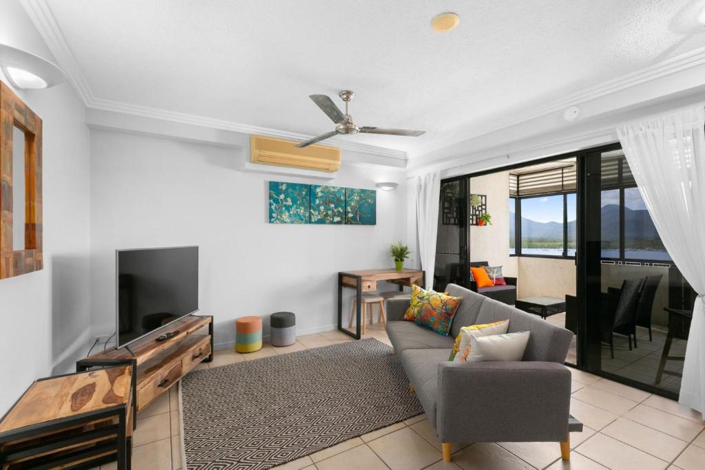 a living room with a couch and a tv at 604 Chic City Apartment with Water Views in Cairns