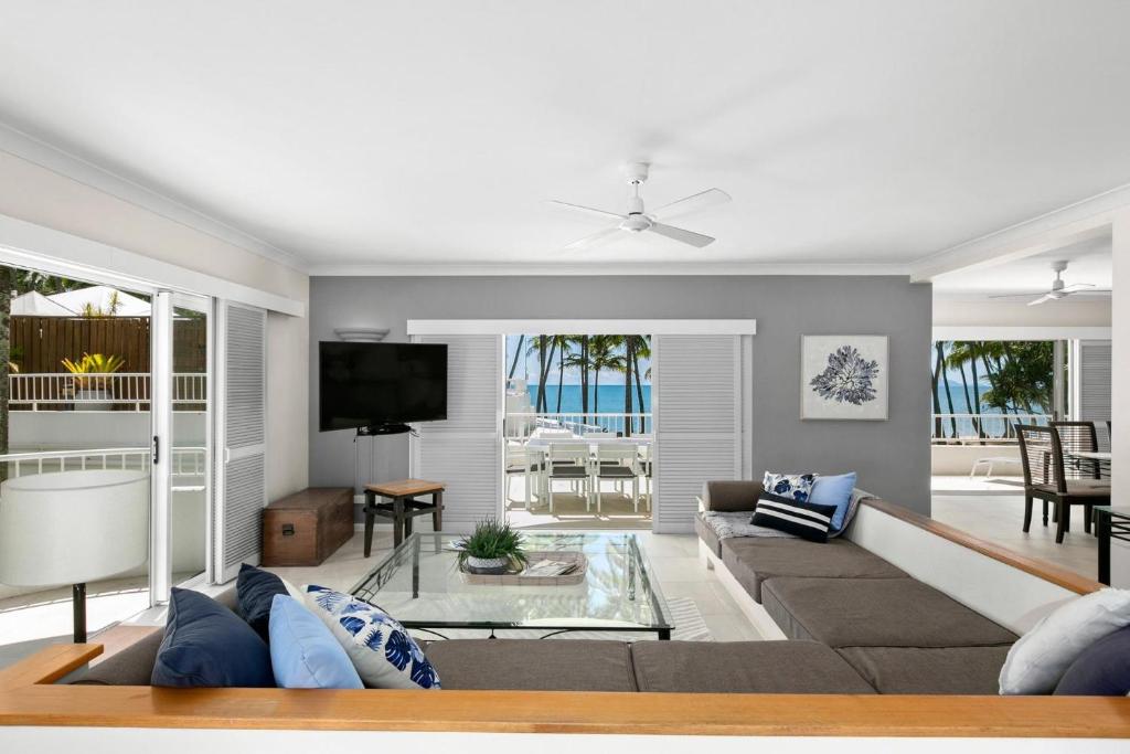 sala de estar con sofá y TV en Belle Escapes Oceanview Suite 48 with Private Pool Alamanda Resort Palm Cove, en Palm Cove
