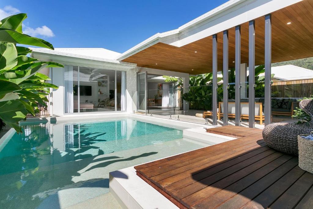 a swimming pool with a deck and a house at Belle Escapes 94 Cascade Luxury Home Palm Cove in Palm Cove