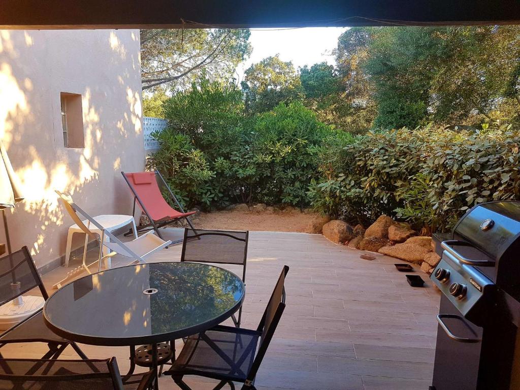 een patio met een tafel en stoelen en een grill bij Maison Porto-Vecchio, 1 pièce, 2 personnes - FR-1-62-159 in Porto-Vecchio