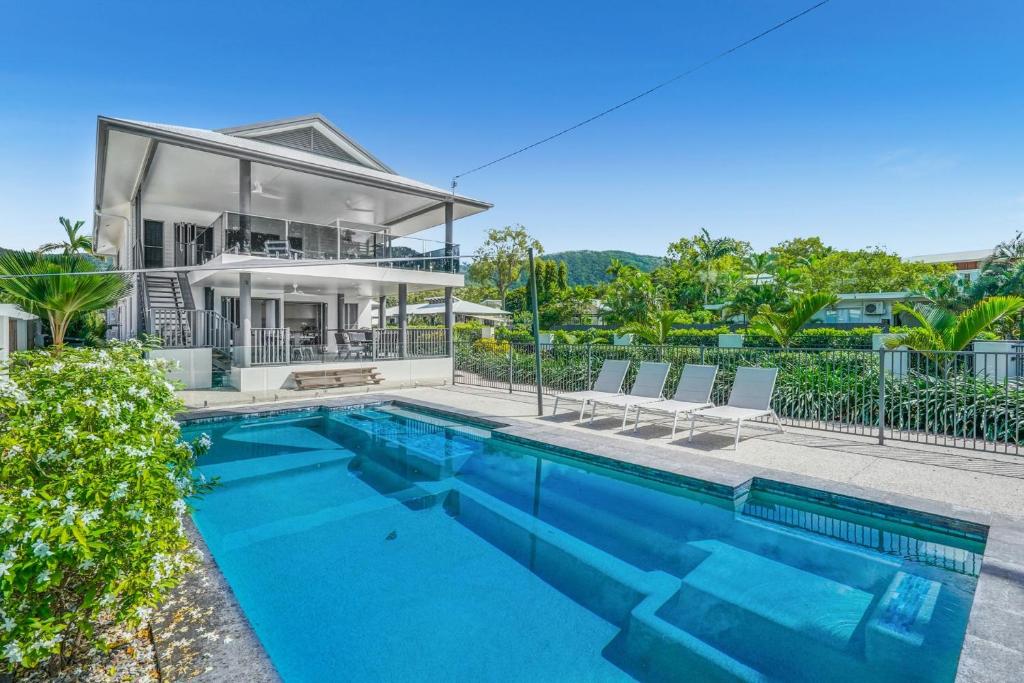 a house with a swimming pool in front of a house at Belle Escapes Beachfront Luxury Home 53 Arlington Clifton Beach in Palm Cove