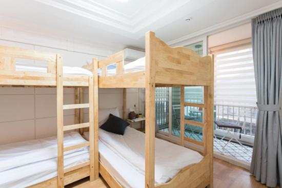 two bunk beds in a room with a balcony at The Blossom Yeonnam Guesthouse in Seoul