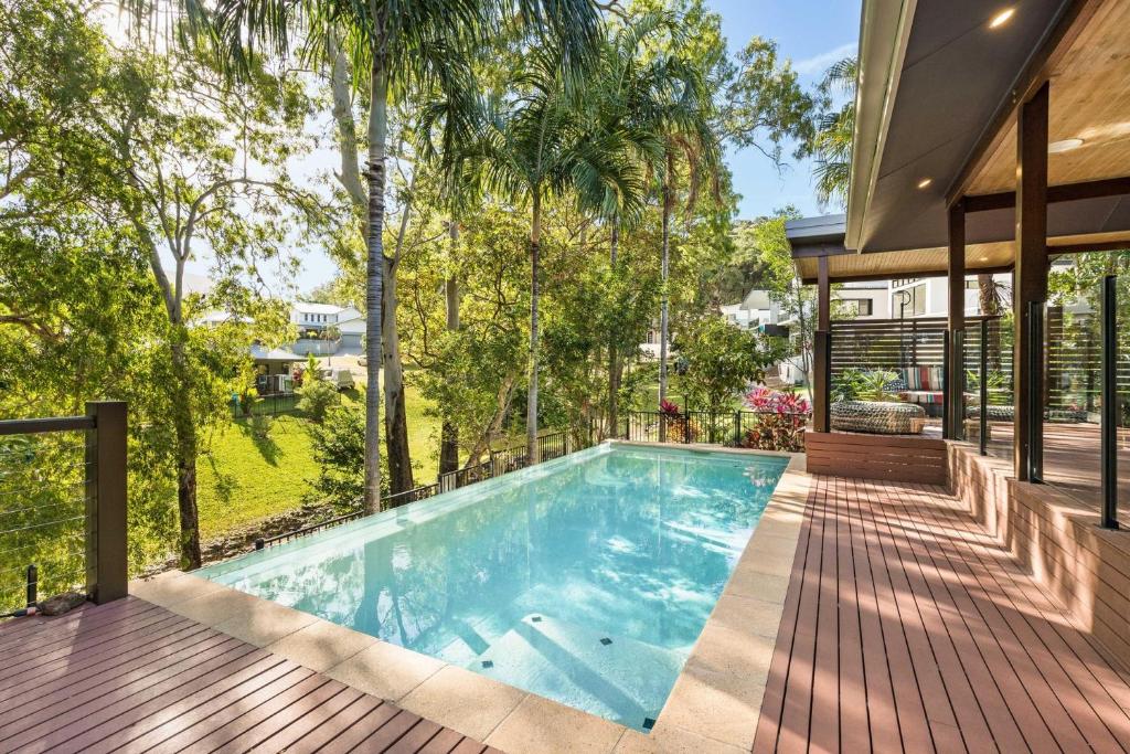 an indoor swimming pool in a house with a deck at Belle Escapes Watermark Palm Cove Luxury Home in Palm Cove