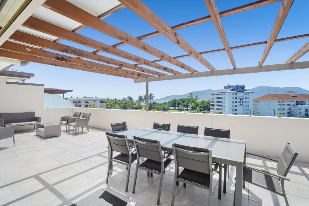 a patio with a table and chairs on a roof at Belle Escapes Waterview Penthouse 404 The Edge in Cairns