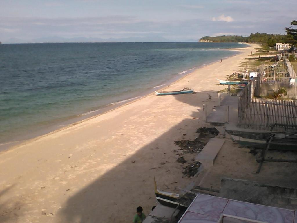 Crystal Jam Resort في Daanbantayan: اطلاله على شاطئ يوجد قوارب عليه