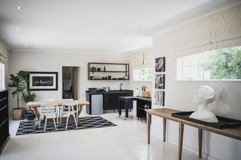 a kitchen and living room with a table and chairs at Stirling Loft in Johannesburg