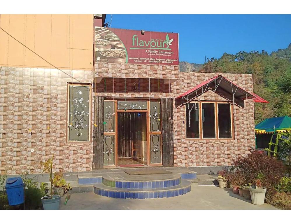 a brick building with a sign on the front of it at Flavours Restaurant And Resort "A unit of Sidhbali Restaurant", Dugadda in Lansdowne