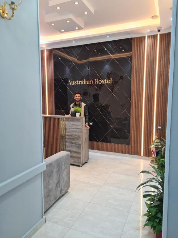 a man standing at a podium in a lobby at The Australian Hostel in Cairo