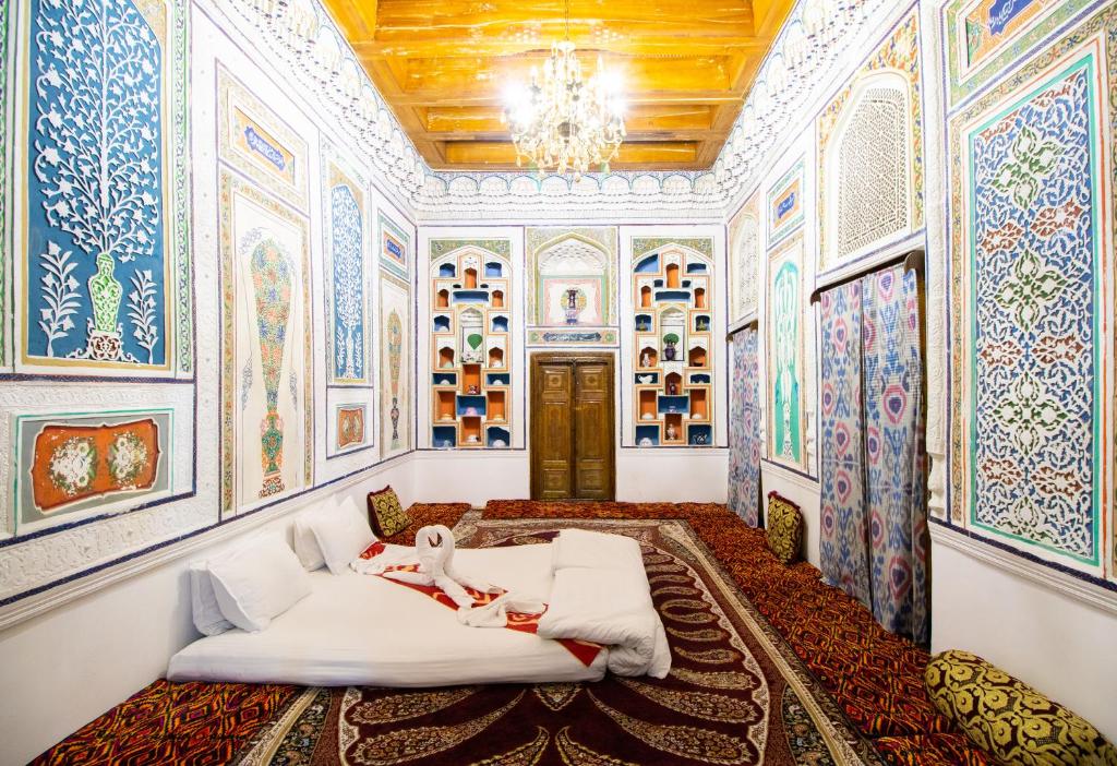 a room with paintings on the walls and a bed at Zaringiz Boutique in Bukhara