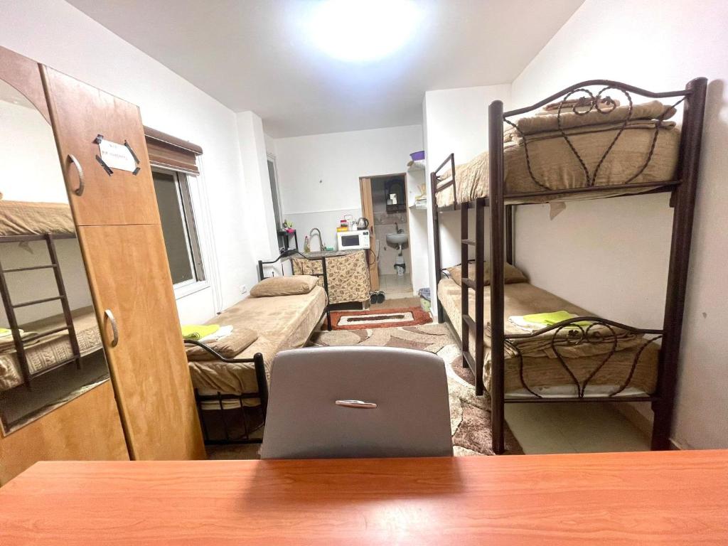 希布倫的住宿－Alsharif family，客房设有双层床和一张带笔记本电脑的书桌。