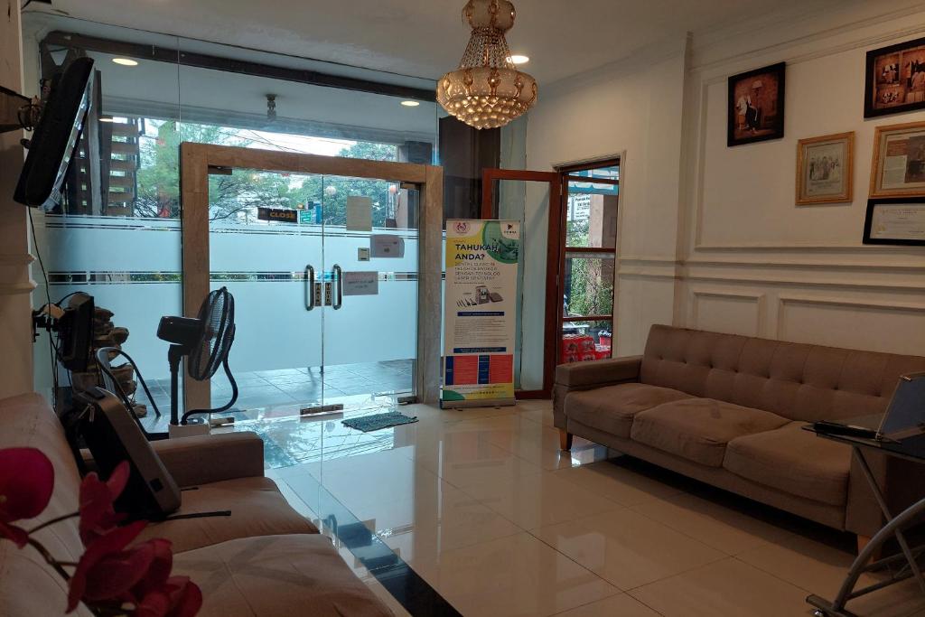 a living room with a couch and a large window at Pondok Sabaraya Haji Juanda Cikampek Purwakarta in Karawang