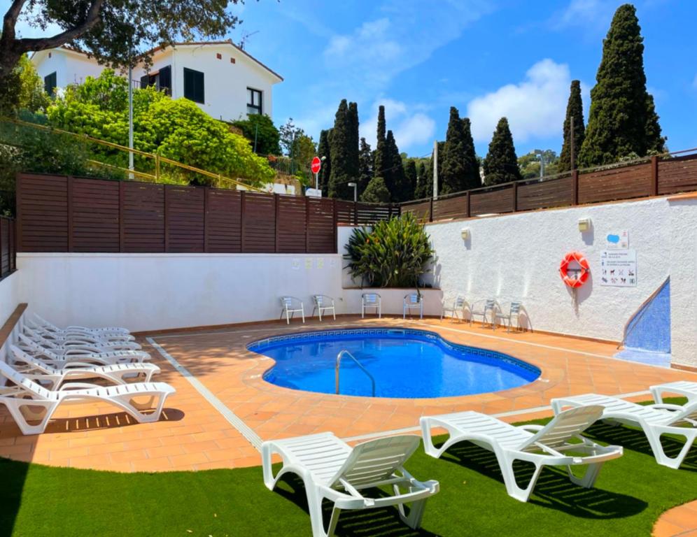 een patio met stoelen en een zwembad bij Hotel Turissa in Tossa de Mar