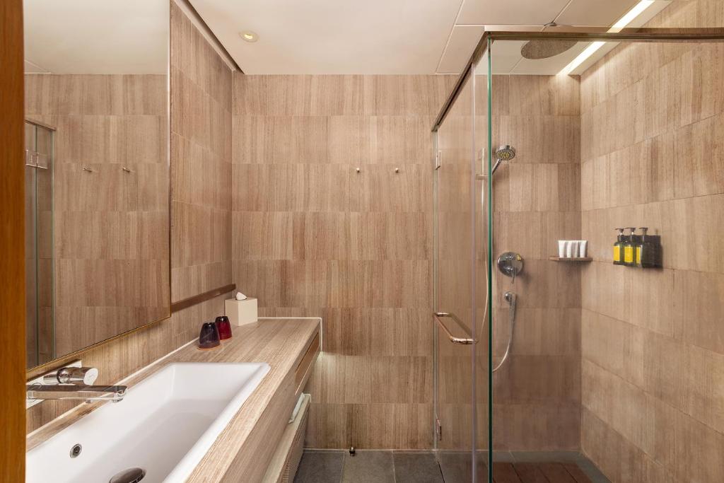 香港にあるNina Hotel Kowloon Eastのバスルーム(洗面台、ガラス張りのシャワー付)