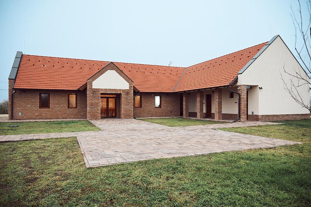 una gran casa de ladrillo con techo rojo en Vadvirág Vendégház, en Izsák