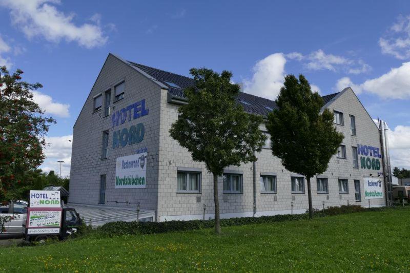 - un grand bâtiment blanc avec un panneau devant dans l'établissement Hotel Nord, à Rheinbach