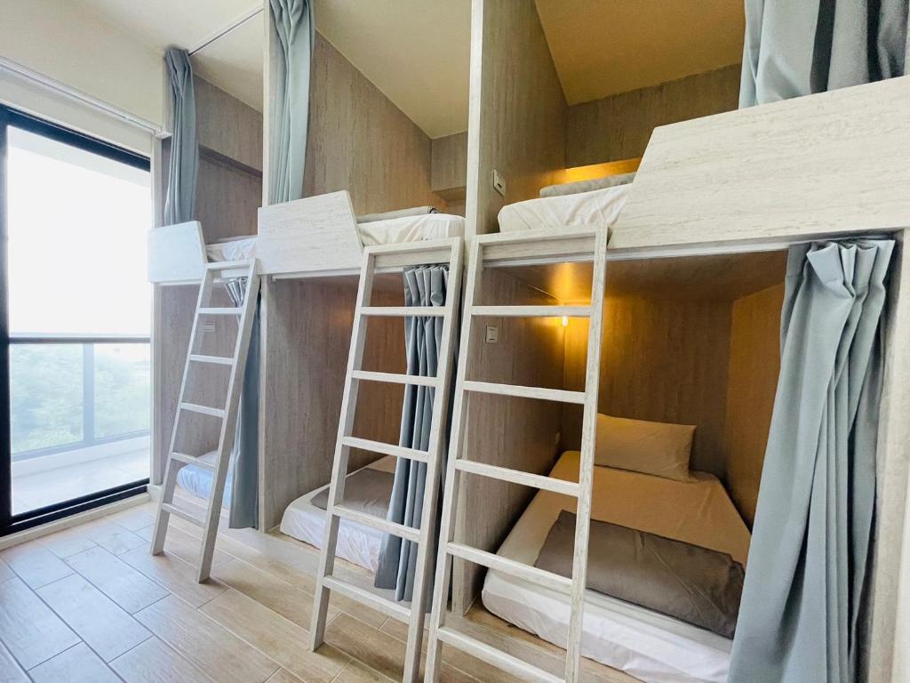 a room with four bunk beds in it at Wind Island B&B in Hsing-wen