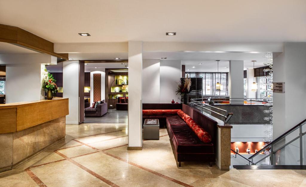 a lobby with a red couch in a building at Hotel Paris Boulogne in Boulogne-Billancourt