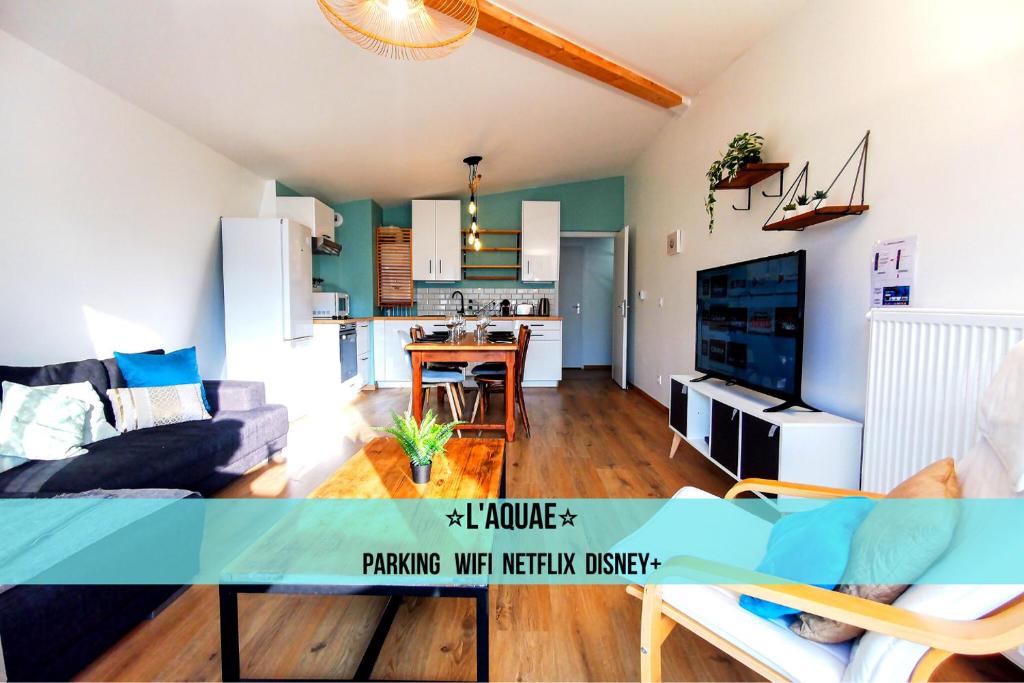 ein Wohnzimmer mit einem Sofa und einer Küche in der Unterkunft L'AQUAE - Parking - Wifi - Netflix in Aix-les-Bains