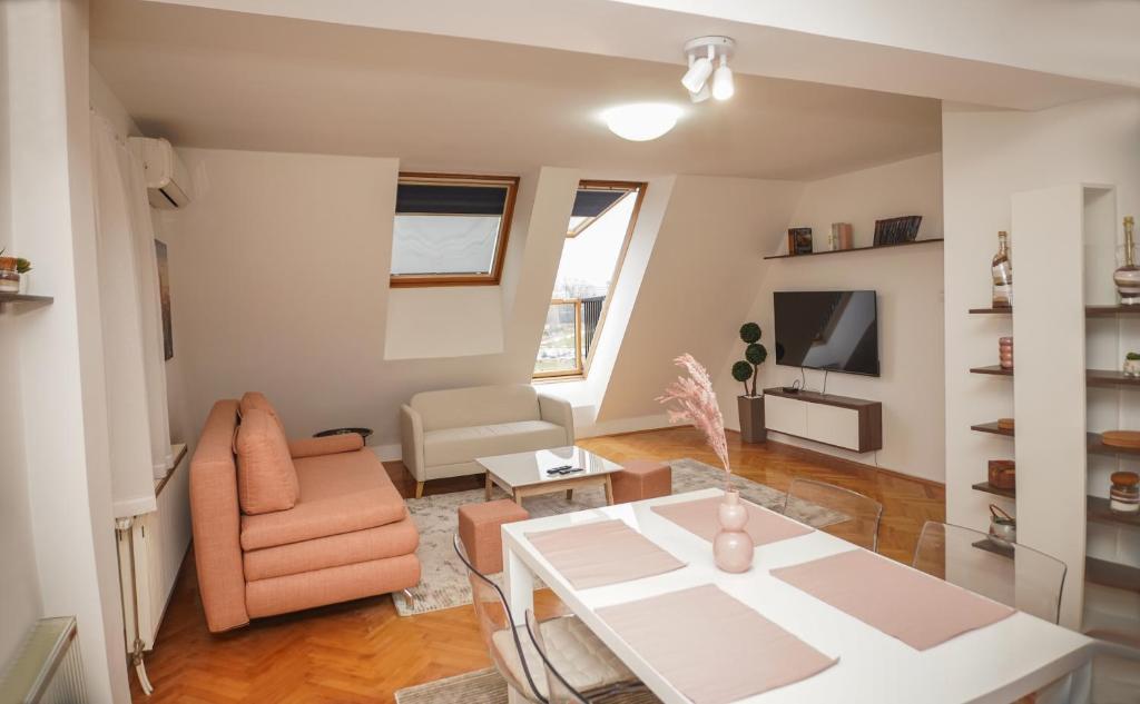 ein Wohnzimmer mit einem weißen Tisch und einem Stuhl in der Unterkunft Sweet69apartments SB in Niš