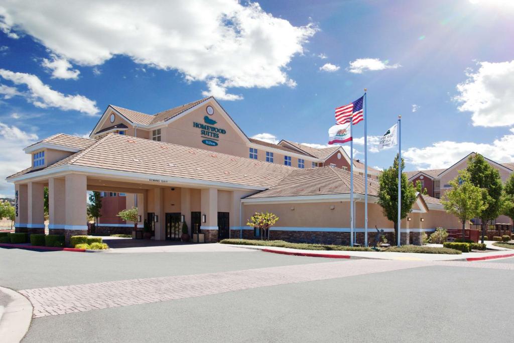 a hotel with two flags in front of a building at Homewood Suites by Hilton Fairfield-Napa Valley Area in Cordelia Junction