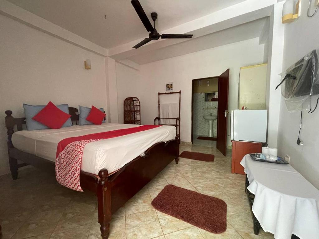 a bedroom with a bed and a ceiling fan at Lavila beach cottage in Wadduwa