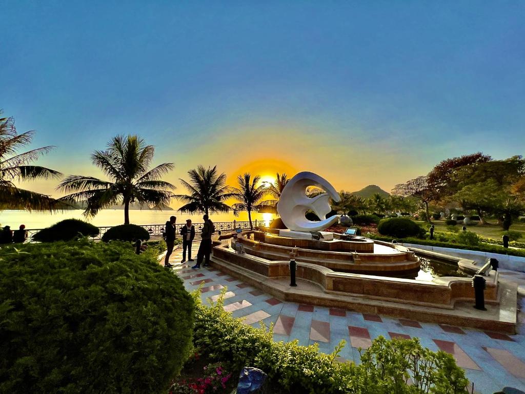 a group of people standing around a fountain in a park at Huong Cang Sea View Hotel in Cat Ba