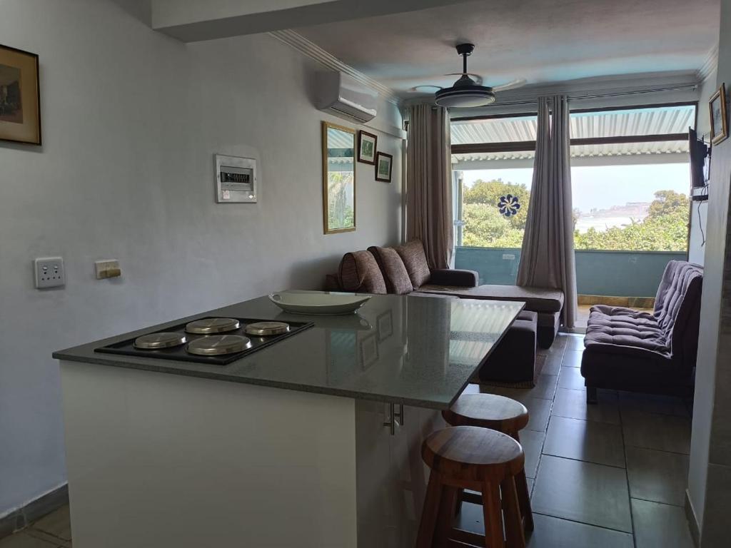 a kitchen with a stove and a living room at Dumela Margate Flat No 12 in Margate
