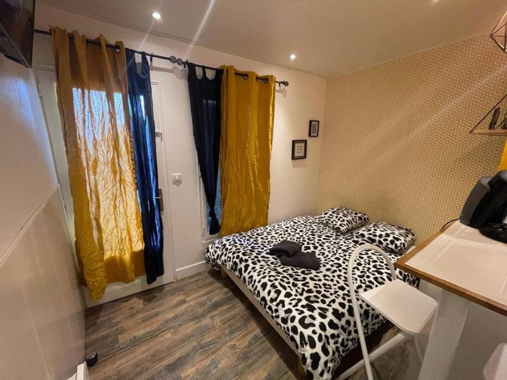 - une chambre avec un lit noir et blanc et des rideaux jaunes dans l'établissement Le Tendance - Centre Historique, calme, WIFI, Netflix, à Niort