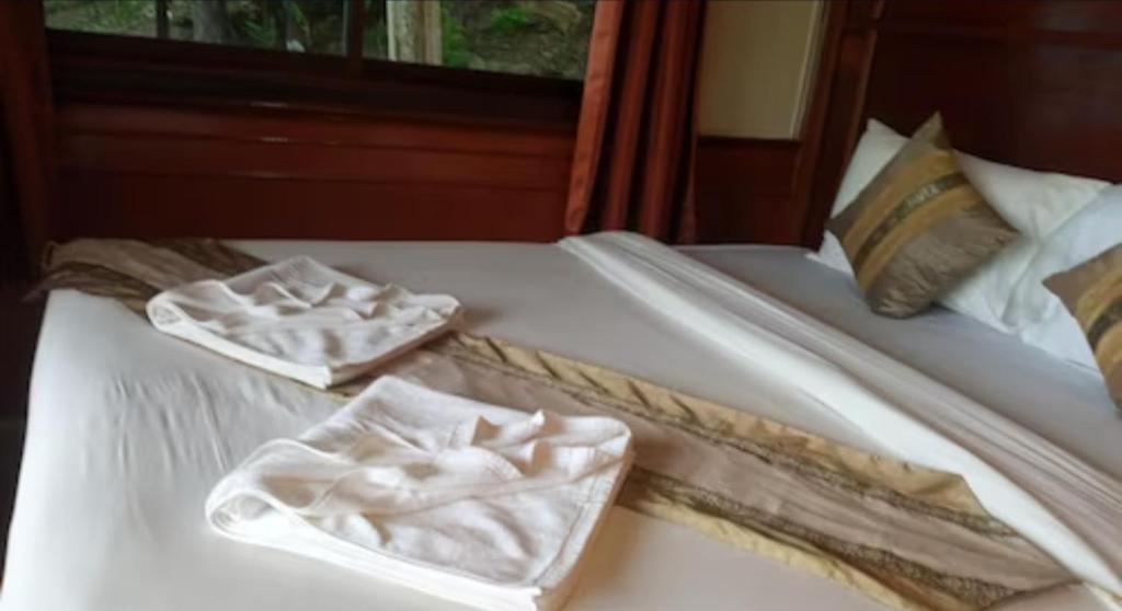 een wit bed met twee vouwhanddoeken erop bij Kantiangparadiseresort in Ban Not (1)