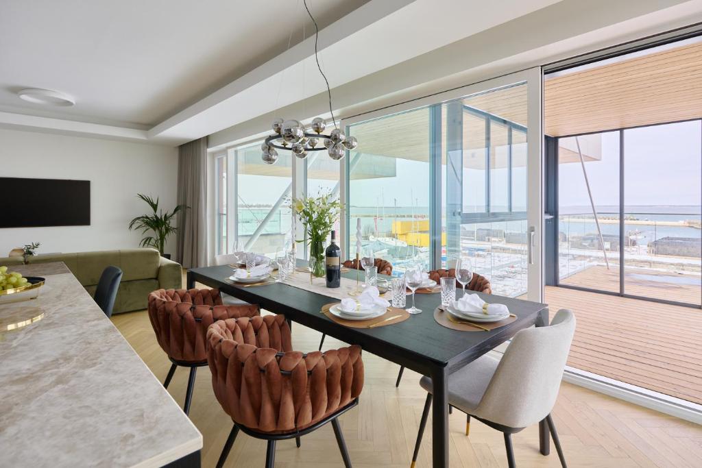 une salle à manger avec une table et des chaises noires dans l'établissement 2023 Luxury Sunset Sea view apartement, à Tallinn