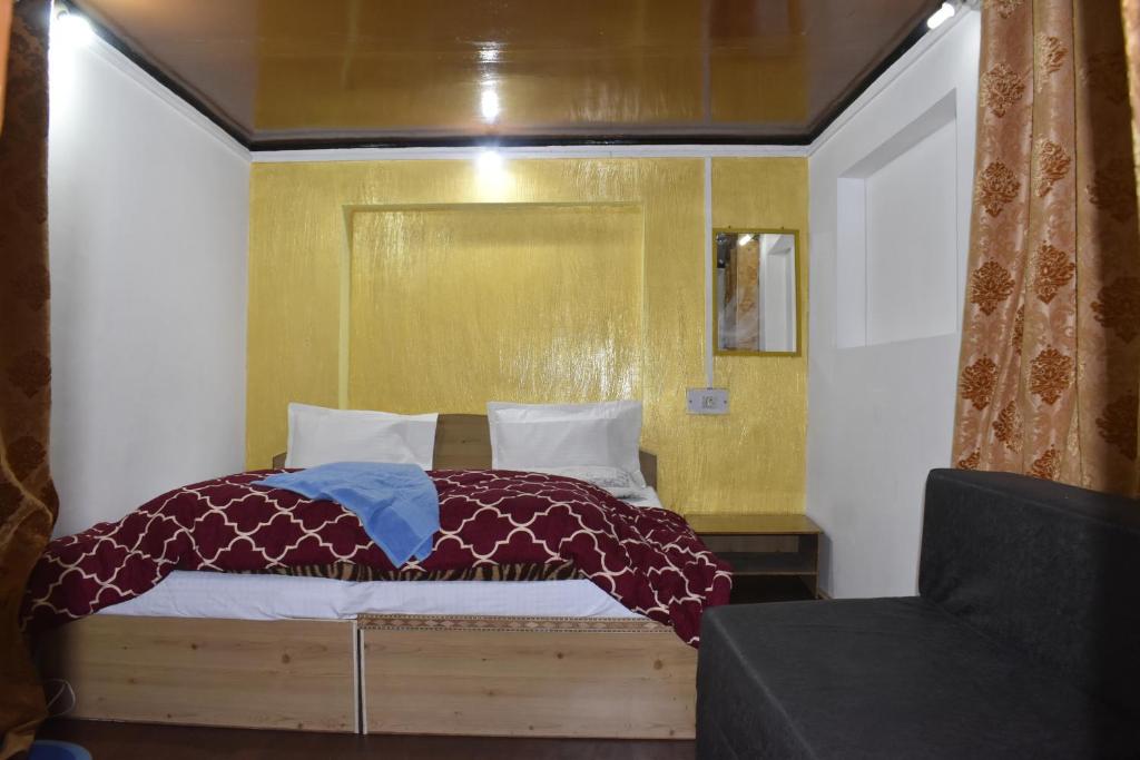 um quarto com uma cama grande e uma parede amarela em Mir guest house em Pahalgām