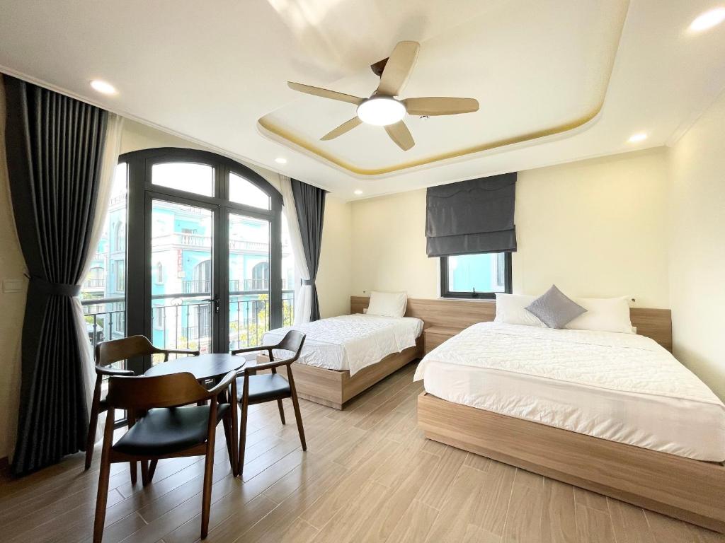 富國的住宿－Cam Hotel Phu Quoc，一间卧室设有一张床、一张桌子、一张床和天花板