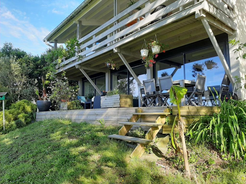 une maison dotée d'une terrasse couverte avec des chaises. dans l'établissement Maison Urt, 4 pièces, 6 personnes - FR-1-239-653, à Urt