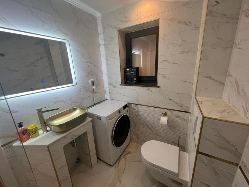 een badkamer met een wastafel en een wasmachine bij Gold delux in Zagreb