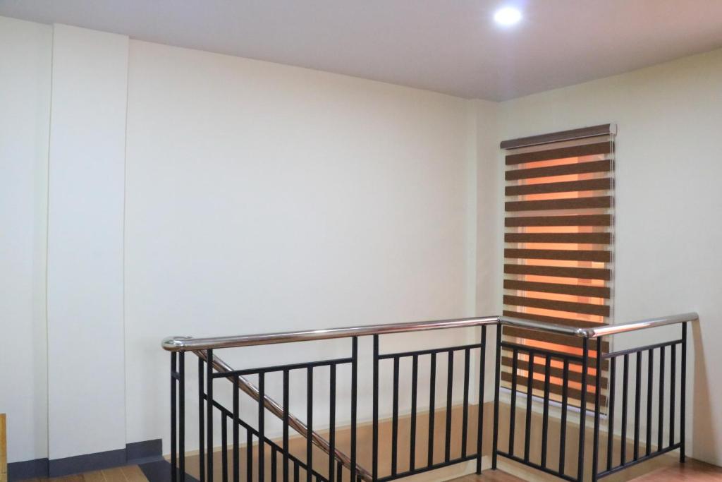a staircase in a room with a white wall at Anicia Guesthouse Units in Manila