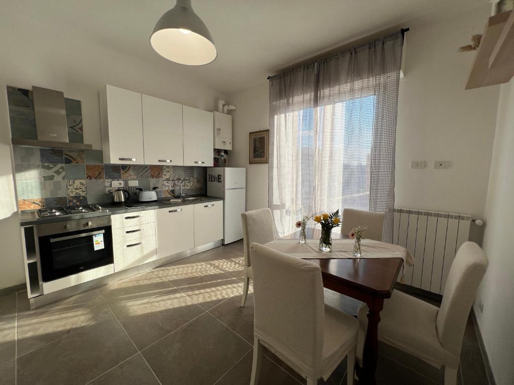 eine Küche mit einem Tisch und eine Küche mit weißen Schränken in der Unterkunft Porpora_Apartment in Florenz
