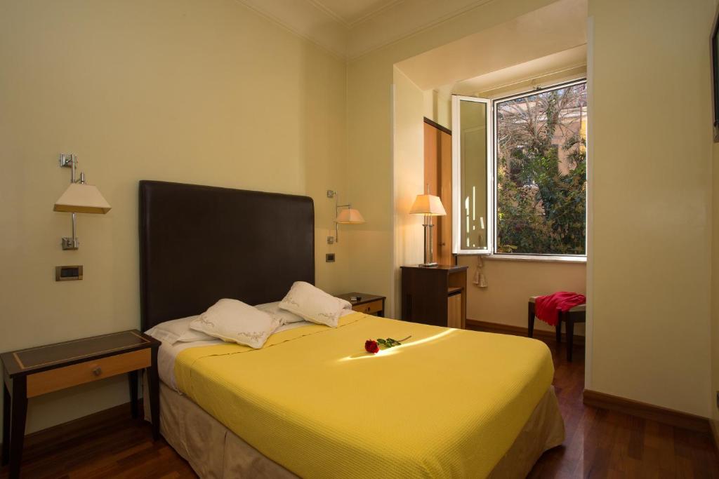 uma cama amarela num quarto com uma janela em Hotel Giolitti em Roma